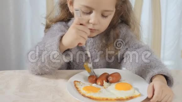 可爱的女孩用叉子吃香肠视频的预览图