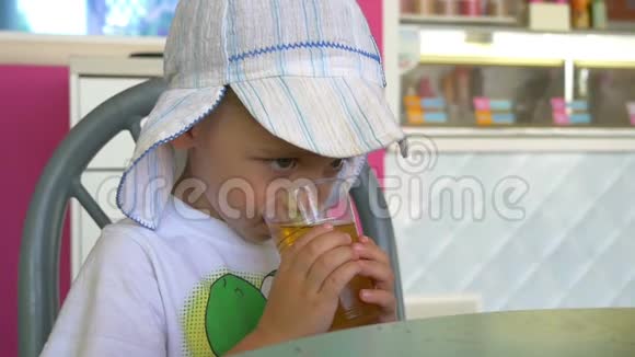 孩子们喝着杯子里的果汁坐在舒适的户外咖啡馆的桌子旁视频的预览图