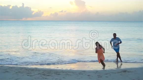 父亲和小女儿在海滩上享受夏日热带假期流动人口视频的预览图
