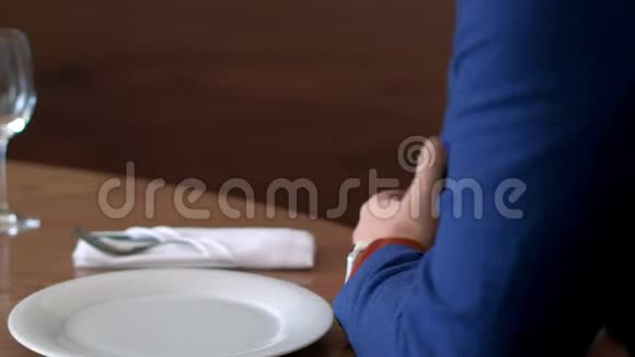 男子点击屏幕智能手表设置移动应用程序在餐桌上的餐厅视频的预览图