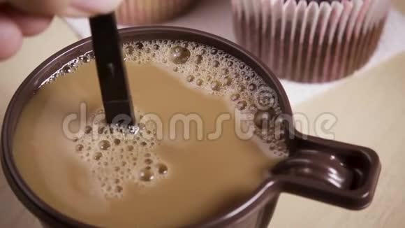 慢动作女人用杯子里的奶油搅拌咖啡视频的预览图