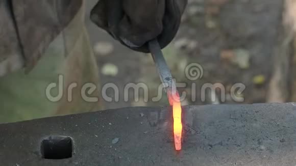 乡村铁匠在铁砧上锻造发光的铁工件视频的预览图