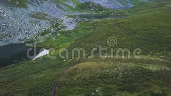 空中拍摄的蓝色池塘反映了美丽的山脉在背景剪辑俯瞰山下的空中景色视频的预览图