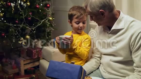 可爱的小男孩帮他爷爷送圣诞礼物视频的预览图
