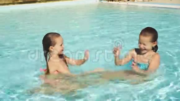 可爱的小女孩一起玩在户外游泳池里玩得开心视频的预览图