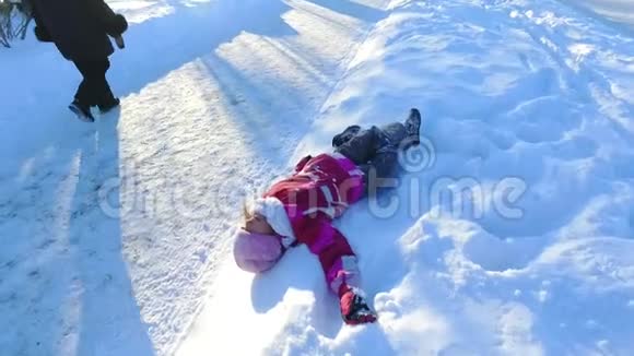 躺在雪地上的小女孩免费儿童在雪地里玩耍视频的预览图