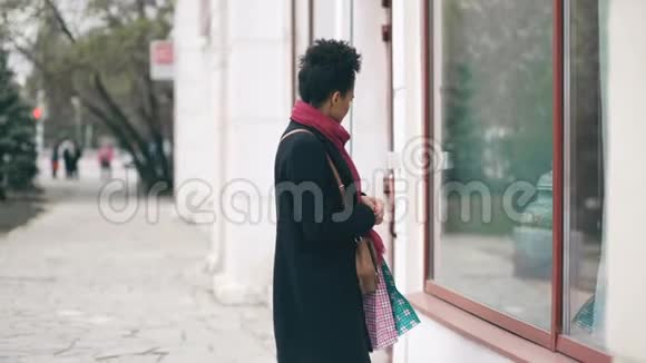 两个漂亮的混血女人带着购物袋在商场附近的大街上相遇视频的预览图