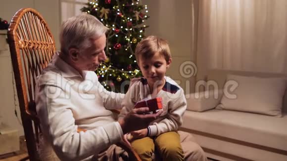 积极的老人和他的孙子在家享受圣诞时光视频的预览图