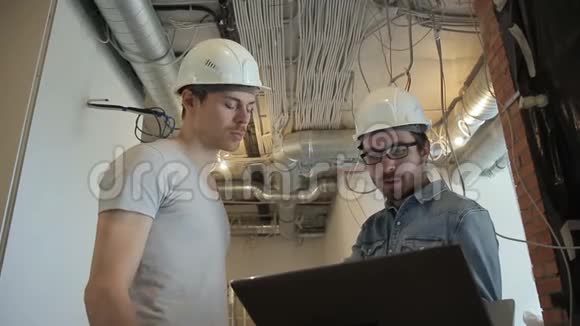 通风系统的两个安装人员看着笔记本电脑脸无胡子的人手里拿着电脑视频的预览图