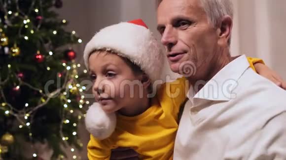 快乐的男孩和他的祖父在玩红色圣诞帽视频的预览图