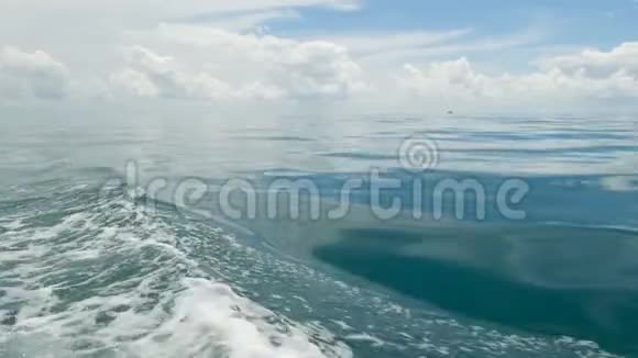在阴天小泡沫的蓝色波浪在一艘船和平静的海洋后热带水景天空反射在视频的预览图