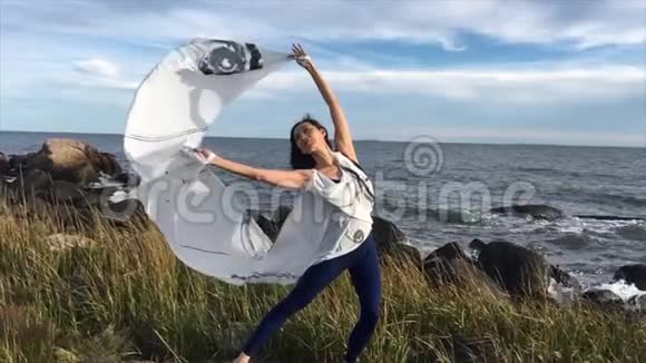 在康涅狄格州的海滩上女人用白色的布料跳舞视频的预览图