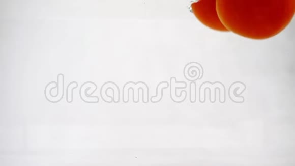 蔬菜西红柿迅速下沉到水中气泡慢动作特写视频的预览图