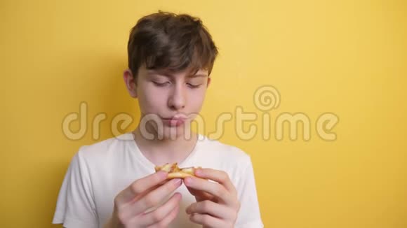 匹萨快乐的青少年男孩吃一片披萨的概念十几岁的男孩饿了吃一片披萨慢动作视频的预览图