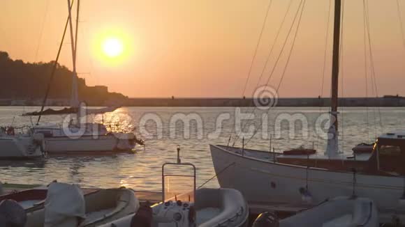 停泊在码头上的渔船浪漫的海景日落视频的预览图