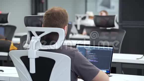 程序员在办公室的笔记本电脑上工作视频的预览图