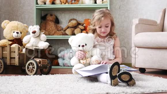 可爱的小女孩和玩具熊一起看书玩玩得开心视频的预览图