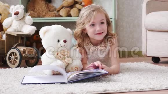 可爱的小女孩带着泰迪熊看书玩玩得开心视频的预览图