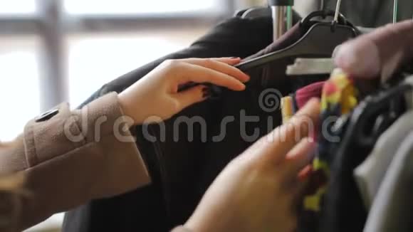 女顾客整理衣架和衣服选择店里买的衣服视频的预览图