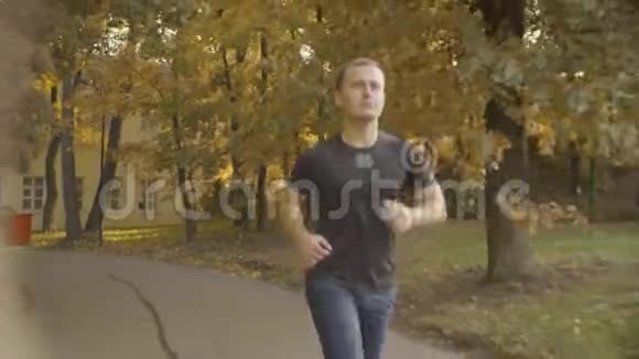 穿着运动服的精力充沛的人在公园的马路上奔跑视频的预览图