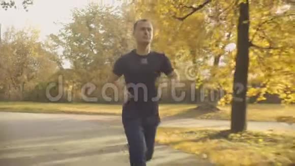 穿着运动服的精力充沛的人在公园的马路上奔跑视频的预览图