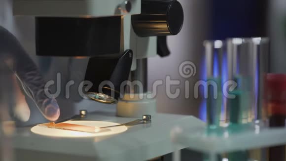 实验室助理从显微镜阶段取出样品下班视频的预览图