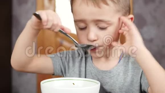 孩子坐在厨房的桌子旁吃面包和汤健康宝宝食品的概念视频的预览图