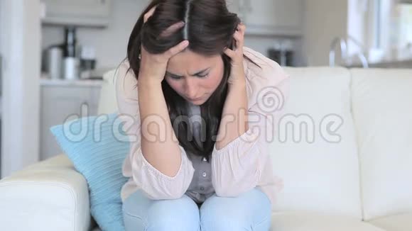 悲伤的女人坐在沙发上视频的预览图
