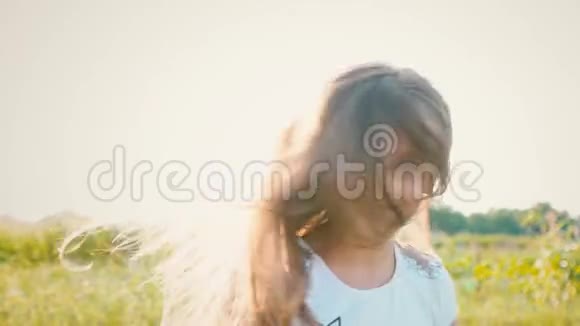 一个迷人的小女孩长着一头飘逸的长发她的头向不同的方向转动风吹起了长发视频的预览图