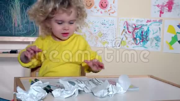 可爱的孩子在她房间的桌子上乱搞视频的预览图