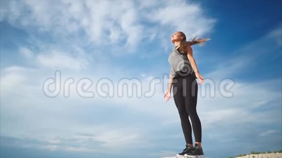 一位年轻女子在大自然中独自做呼吸运动清新的风吹拂着她视频的预览图