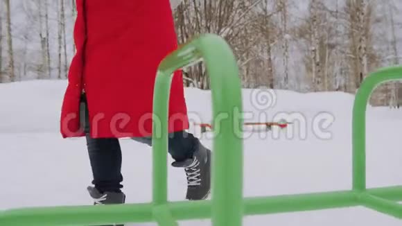 穿着红色夹克衫头罩走路的女孩在雪地里独自行走视频的预览图
