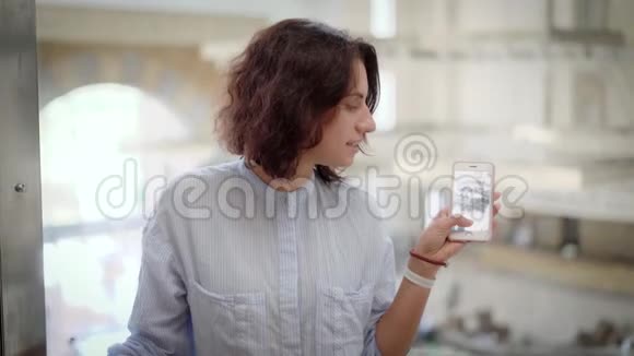 一位卷发女士爬上电梯一位女士通过手机上的玻璃拍摄照片或视频视频的预览图