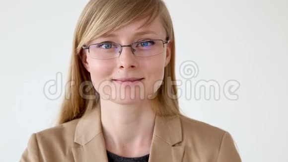 一位戴眼镜的快乐商务女性的肖像和一件白色背景的夹克特写视频的预览图