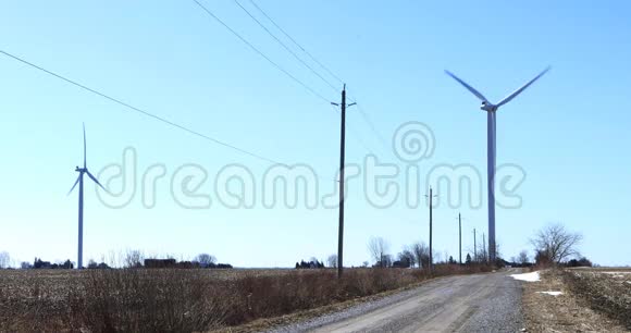 沿着宁静的乡村道路行驶的风力涡轮机视频的预览图