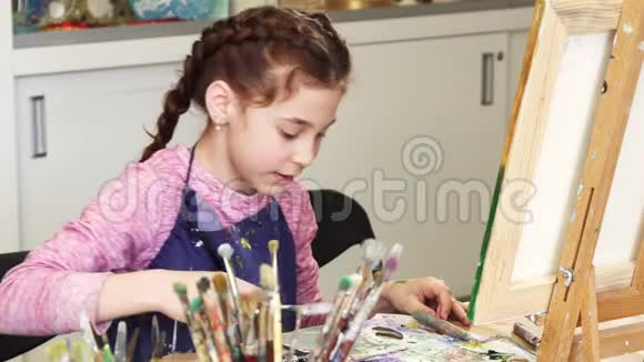 在艺术工作室对着镜头微笑的小女孩视频的预览图