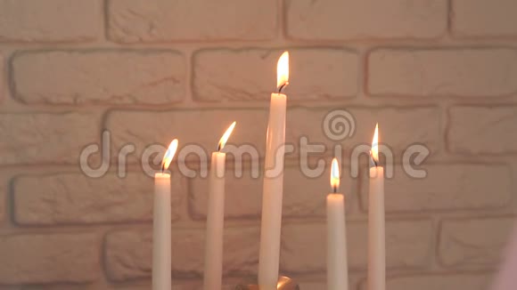 五支燃烧的蜡烛贴在砖墙上视频的预览图