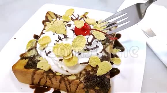 美味的烤面包在盘子上上面有蜂蜜巧克力糖浆和鲜奶油撒在玉米片上上面有樱桃视频的预览图