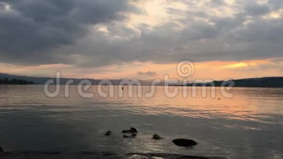 日落的背景下山的湖在城市视频的预览图