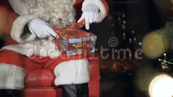 圣诞老人在礼品盒上系丝带平安夜概念视频的预览图