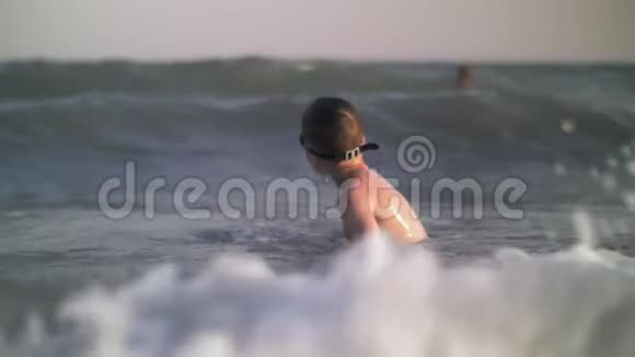 孩子在海里洗澡海浪拍打着他视频的预览图