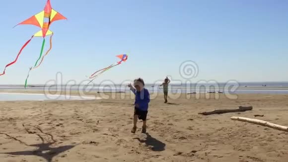 男孩们在海滩上带着风筝跑步视频的预览图