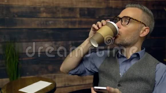 男人用电话在咖啡馆喝咖啡视频的预览图