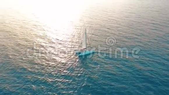 空中观景双体船经过海上相机靠近飞过船只日落时美丽的景色视频的预览图