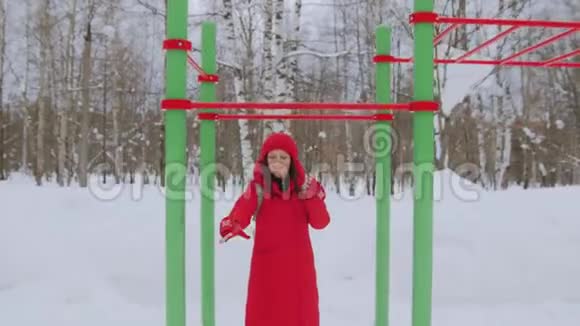 穿着红色夹克衫头罩走路的女孩在雪地里独自行走视频的预览图