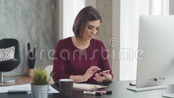时尚的现代女性在办公室工作坐在桌子旁视频的预览图