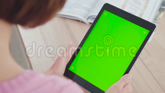 拍在肩膀上年轻女子用的是一块带有绿色屏幕的平板电脑视频的预览图