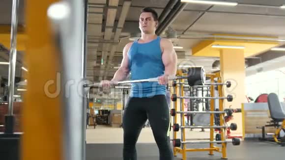 健身房健身肌肉男用杠铃二头肌滑杆进行锻炼视频的预览图