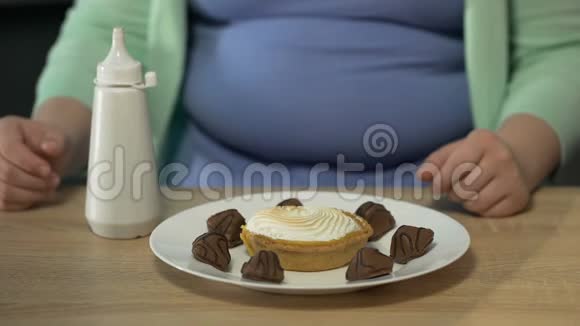 肥胖的女孩子在盘子里放了很多巧克力调料视频的预览图