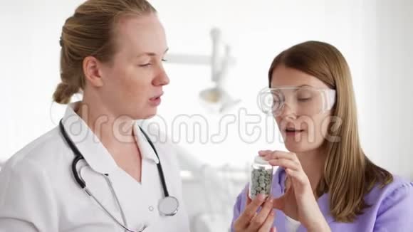 两位带药片的女医生在医院讨论新的治疗方法一瓶药丸视频的预览图